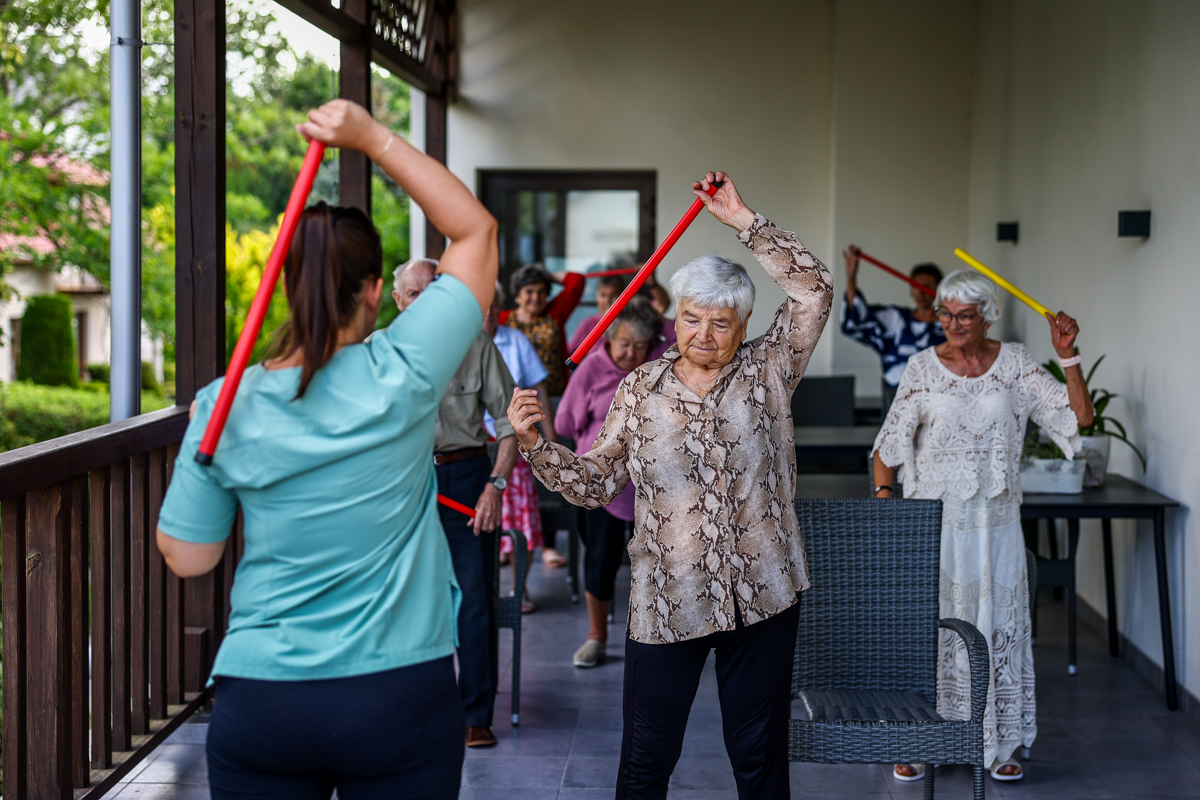 Seniorzy ćwiczą na tarasie.