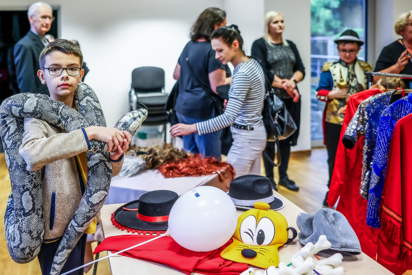 Grupka osób w różnym wieku w garderobie teatralnej.