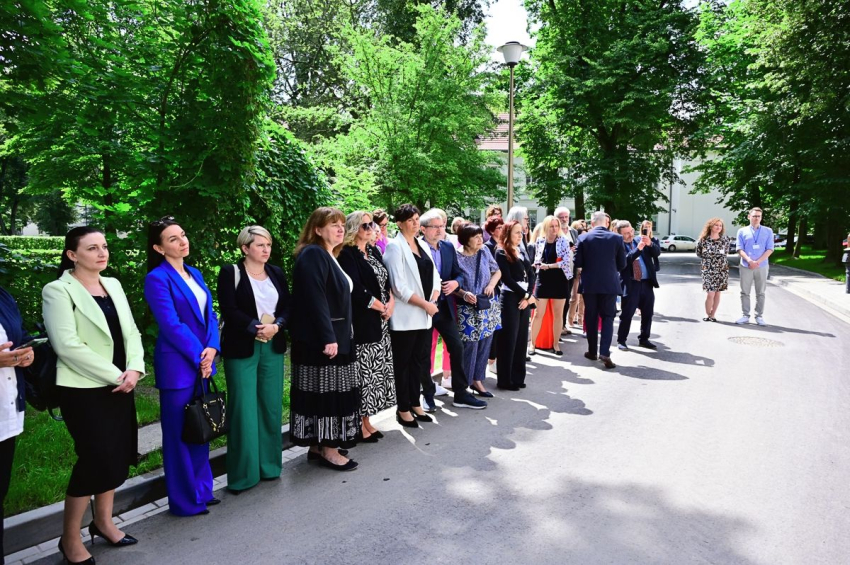 Grupa osób stojąca w parku.