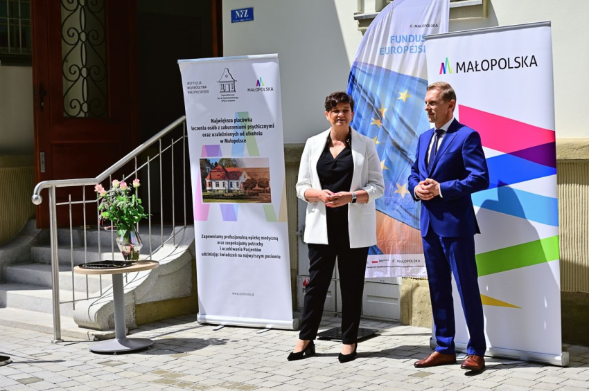 Kobieta i mężczyzna stojący obok wejścia do budynku na terenie parku.