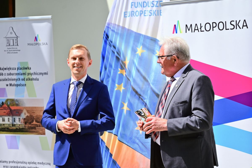 Młody i starszy mężczyzna stoją przed budynkiem .