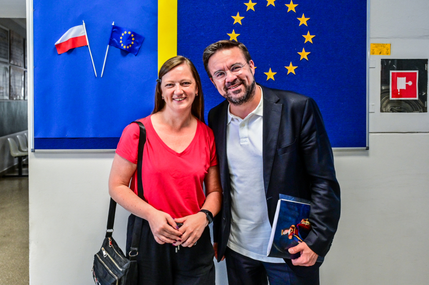 Kobieta i mężczyzna na tle flagi Unii Europejskiej.