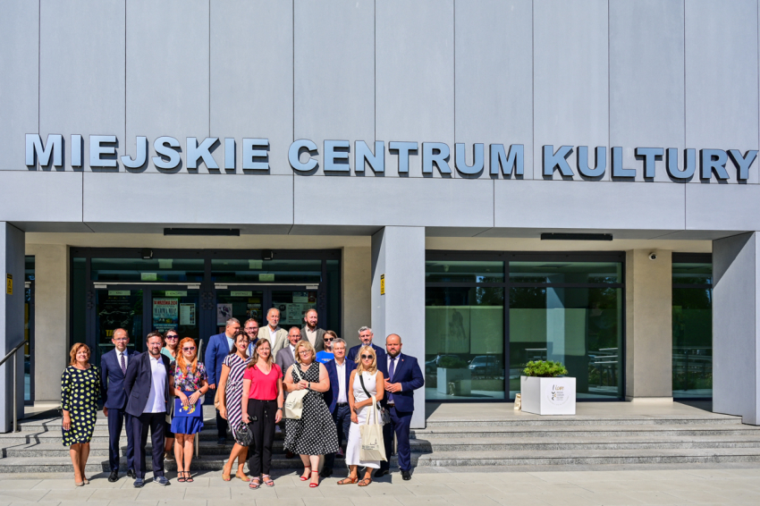 Zdjęcie grupowe na schodach nowoczesnego Miejskiego Centrum Kultury.