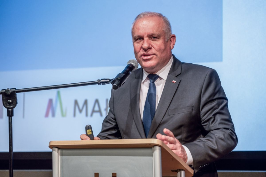 Mężczyzna przemawia do mikrofonu.