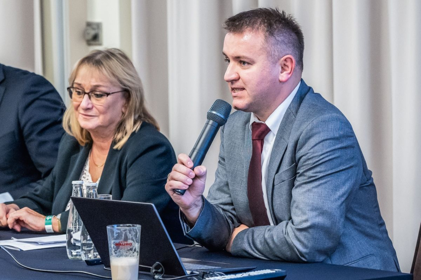 Mężczyzna przemawia do mikrofonu.