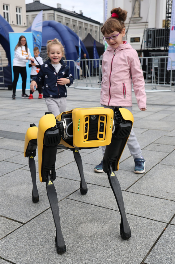 Dziewczynki oglądają nowoczesnego małego robota.