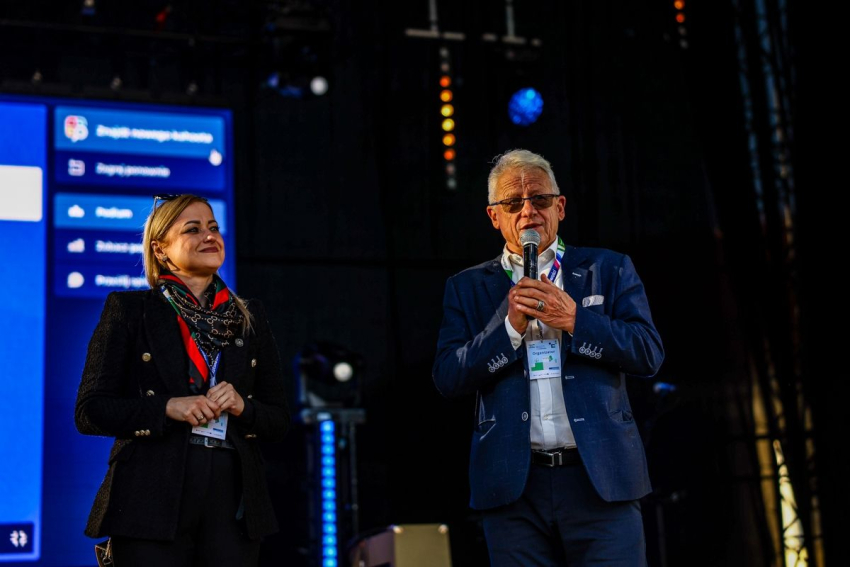 Mężczyzna na scenie przemawia do mikrofonu.