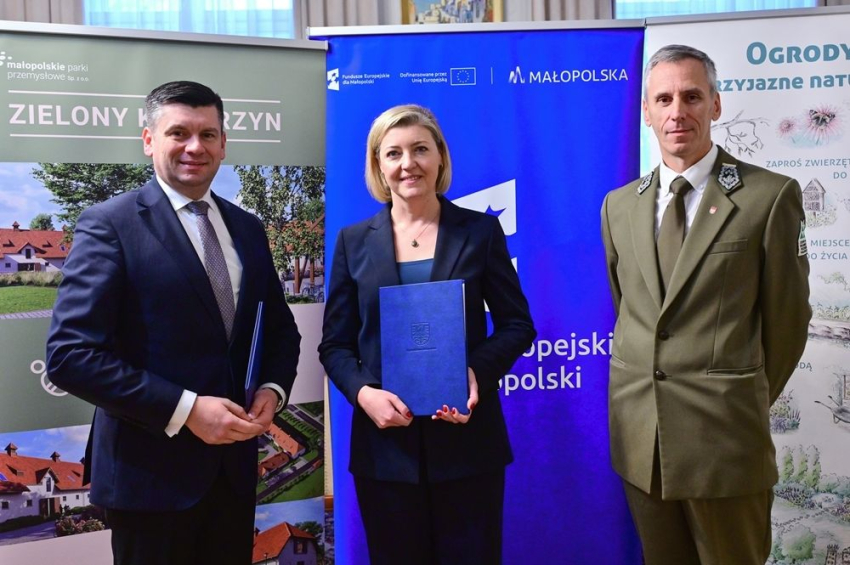 Marszałek Małopolski z z kobietą i mężczyzną w zielonym mundurze.