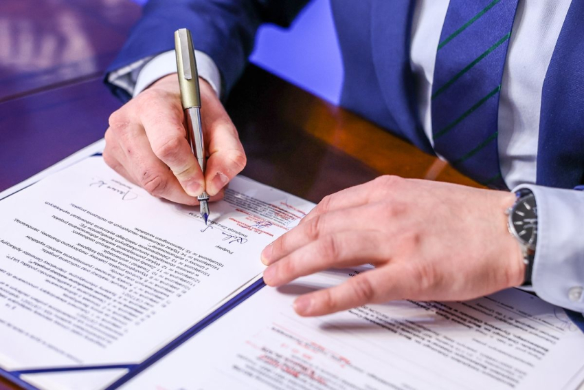 Marszałek Łukasz Smółka podpisuje umowę. Ujęcie dłoni.