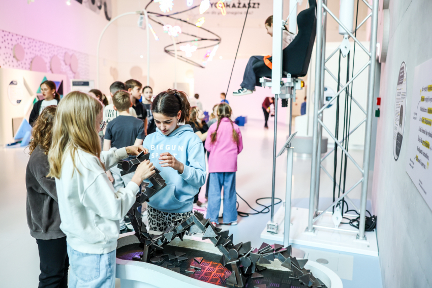 Wystawa stała. Dzieci łączą metalowe elementy, z których powstaje smok.