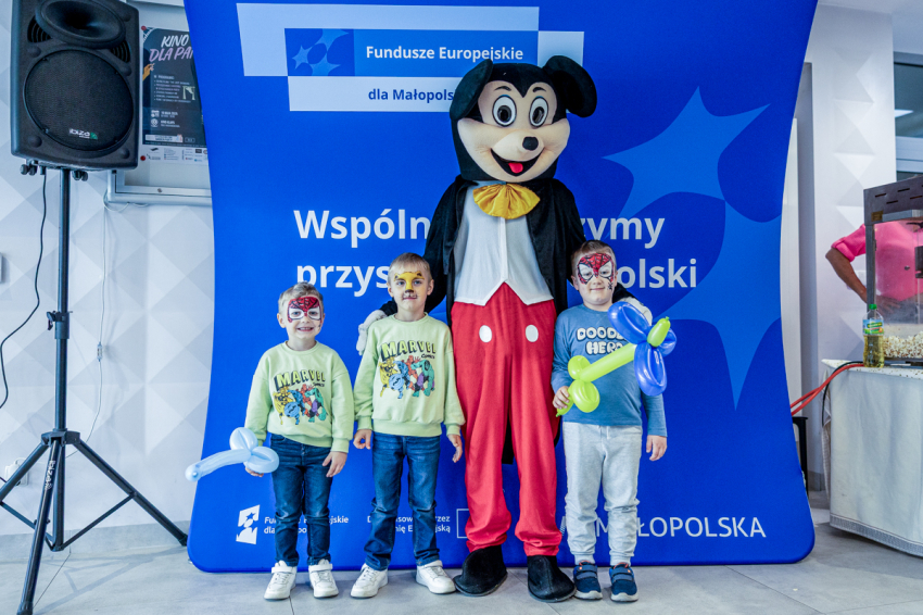 Dzieci pozują z maskotką Myszki Miki.