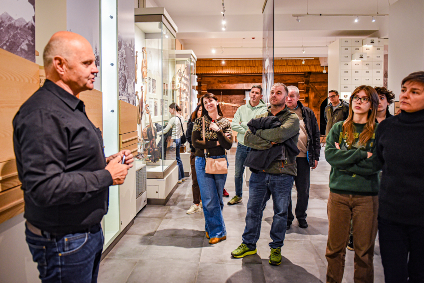 Przewodnik opowiada zwiedzającym historie w Muzeum Tatrzańskim.