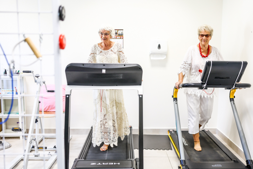 Dwie seniorki ćwiczą na bieżni.