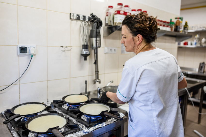 Kobieta gotująca posiłek w kuchni.