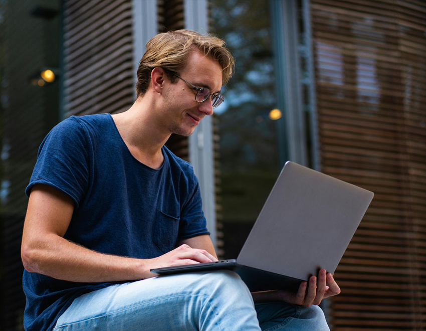 Młody chłopak pracuje na laptopie.