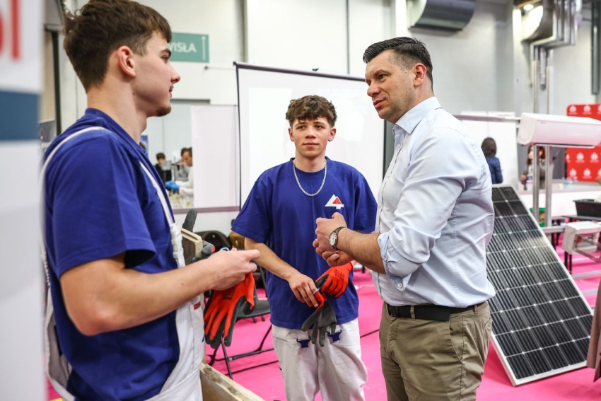 Marszałek rozmawia z dwoma chłopcami w wieku nastoletnim.