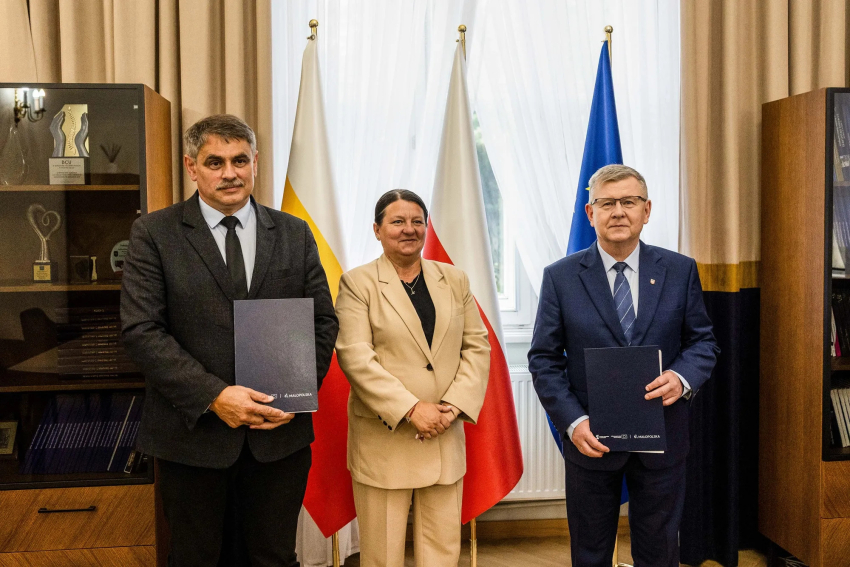 Wicemarszałek Witold Kozłowski, Burmistrz Kalwarii Zebrzydowskiej Tadeusz Stela z umowami. Pośrodku stoi kobieta.