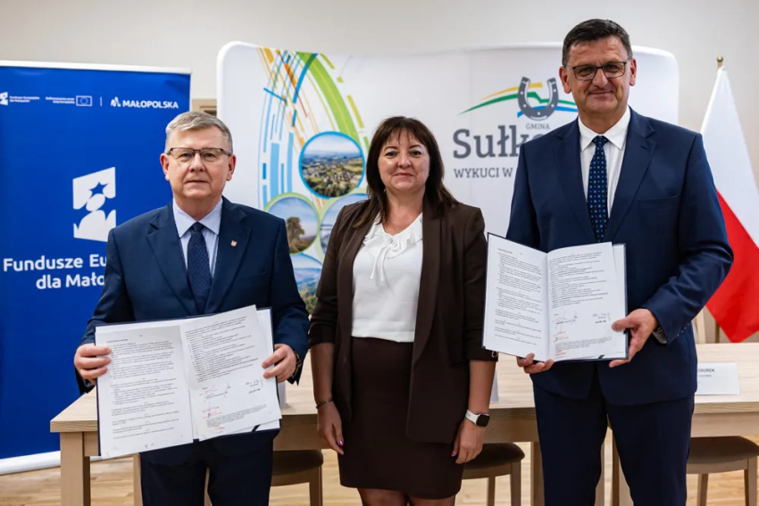 Wicemarszałek Kozłowski i Burmistrz Sułkowic z umowami. Pośrodku nich kobieta.
