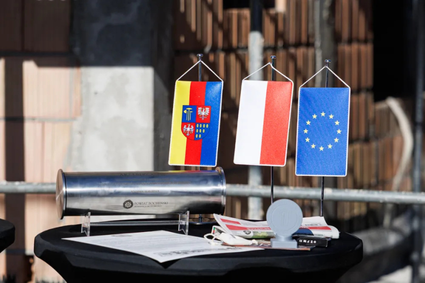 Akt w metalowej tubie, flagi: Polski, Unii Europejskiej i powaitu bocheńskiego