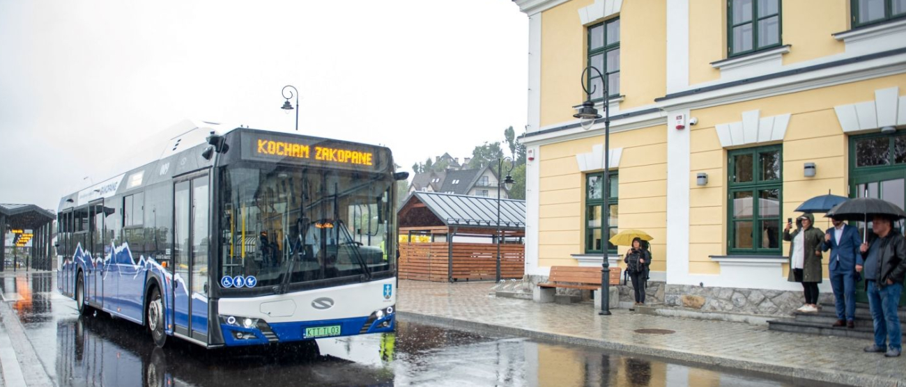 Autobus stoi przed nowym budynkiem dworca autobusowego w Zakopanem. Deszczowy dzień.