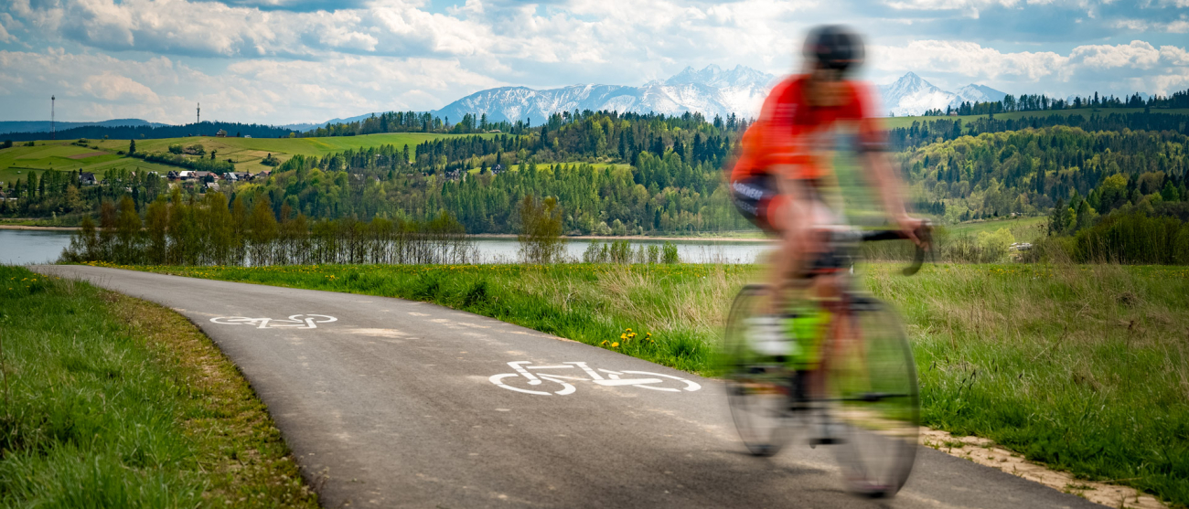 Rowerzysta jadący ścieżką rowerową dookoła jeziora.
