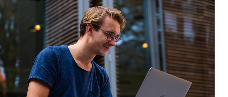 Młody chłopak pracuje na laptopie.