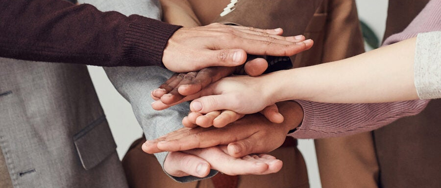 Ręce ułożone jedna na drugiej w geście partnerstwa.