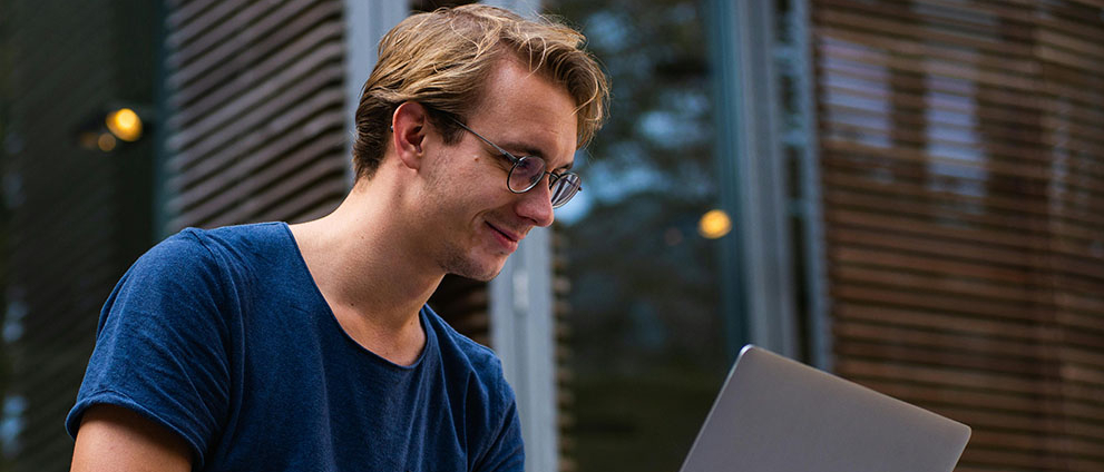 Młody chłopak pracuje na laptopie.