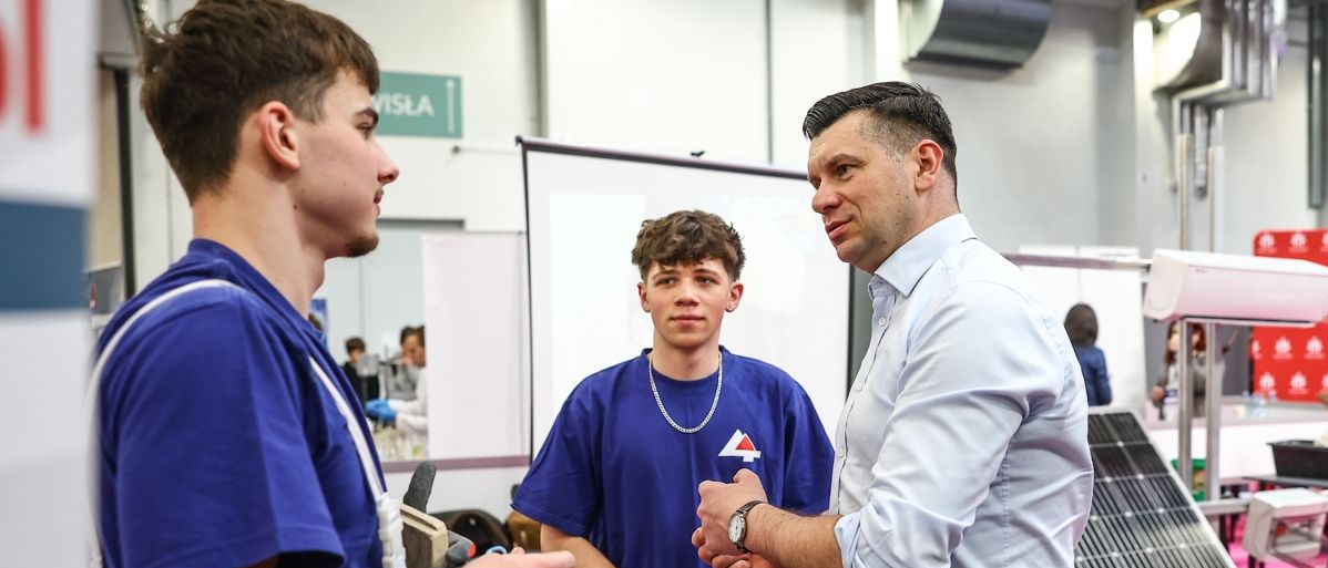 Marszałek rozmawia z dwoma chłopcami w wieku nastoletnim.