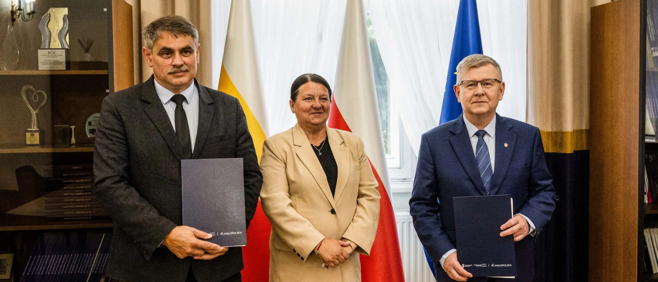 Wicemarszałek Witold Kozłowski, Burmistrz Kalwarii Zebrzydowskiej Tadeusz Stela z umowami. Pośrodku stoi kobieta.
